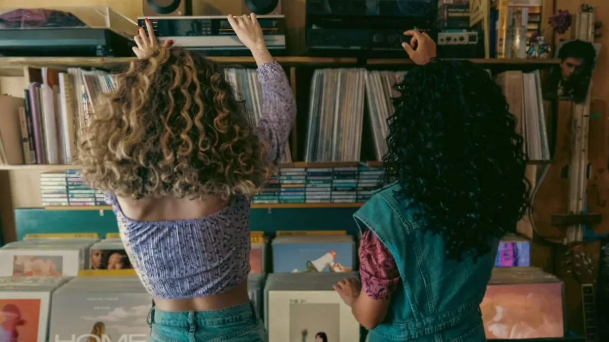 Two women browsing vinyl records in a record store.